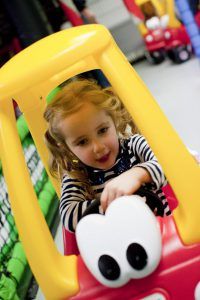 Little girl on the kart track of Toddler Town at Kidabulous