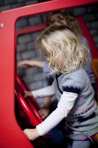 Little girl at the wheel of a car in Toddler Town