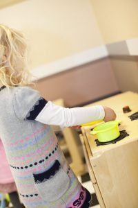 Little girl cooking in the Toddler Town cafe
