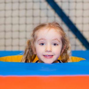 Little girl smiling in soft play area of Kidabulous, Surrey